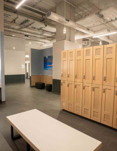 A locker room with wooden lockers and a bench.