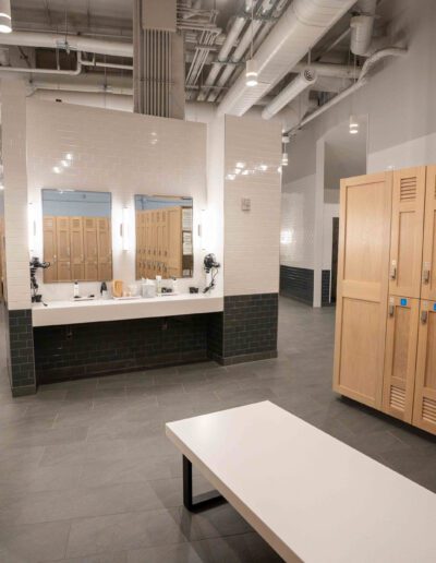 A locker room with wooden lockers and a bench.