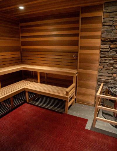 A sauna room with wooden benches and a fireplace.