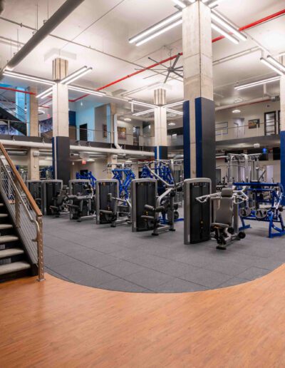A gym with a lot of equipment and stairs.
