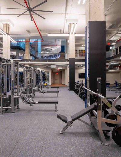 A gym with a lot of equipment and weights.