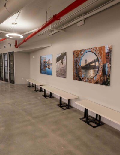 A hallway with benches and pictures hanging on the wall.
