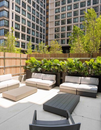 A patio area with couches and a wooden fence.