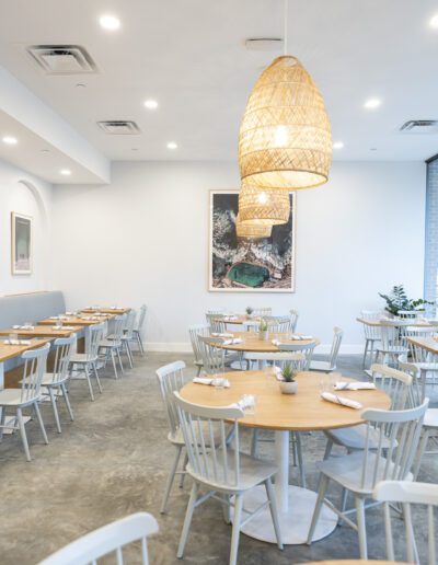 The interior of a restaurant with white tables and chairs.