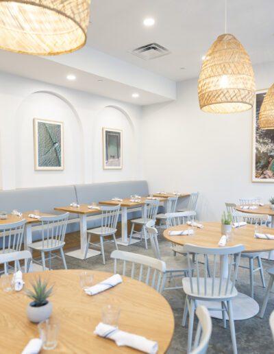The interior of a restaurant with white tables and chairs.