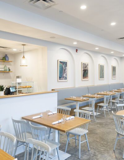 A restaurant with white tables and chairs.