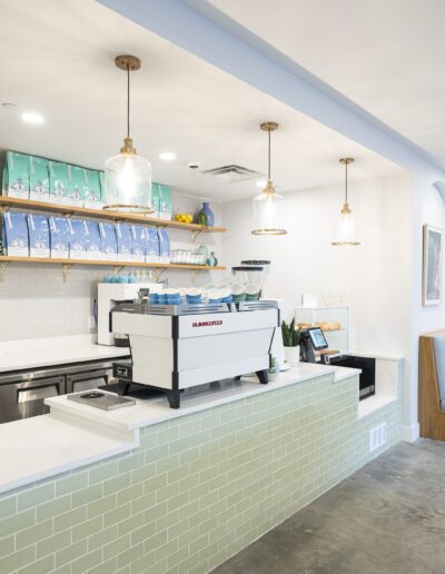 The interior of a coffee shop with a green tiled wall.