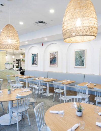 The interior of a restaurant with white tables and chairs.