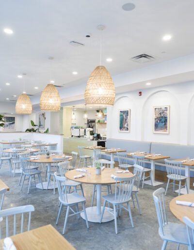 The interior of a restaurant with white tables and chairs.